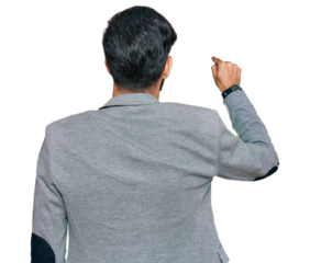 Young hispanic man wearing business clothes posing backwards pointing ahead with finger hand