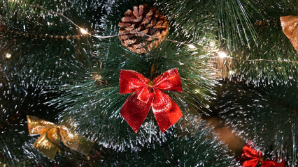 Close-up of a nice red bow hanging on a Christmas tree