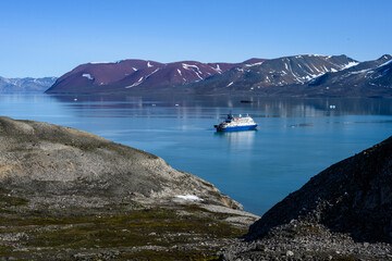Arctic cruise ship in Liefde Fjord, Svalbard, expedition tourism in the high arctic viewed from a...
