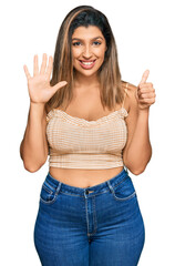 Beautiful brunette woman wearing casual clothes showing and pointing up with fingers number six while smiling confident and happy.