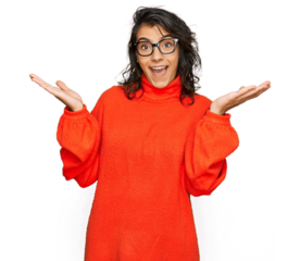 Young hispanic woman wearing casual clothes and glasses celebrating victory with happy smile and winner expression with raised hands