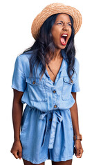 Young indian girl wearing summer hat angry and mad screaming frustrated and furious, shouting with anger. rage and aggressive concept.