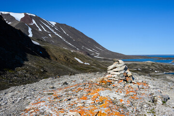 Rock cairn on a mountain top in Liefde Fjord, Svalbard, expedition tourism in the arctic summer