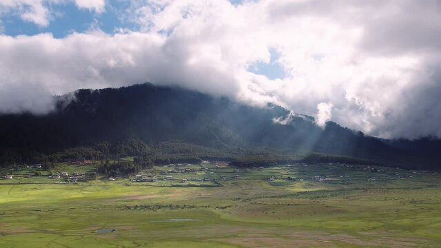 View of scenic landscape with mountains and clouds in Bhutan, view of the meadows in Phobjikha valley in Bhutan.