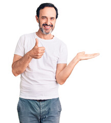 Middle age handsome man wearing casual t-shirt showing palm hand and doing ok gesture with thumbs...