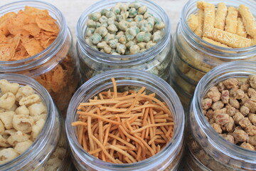 Rows of Indonesian various snacks in jars on the  table 