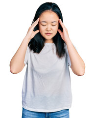 Young chinese woman wearing casual white t shirt with hand on head for pain in head because stress. suffering migraine.