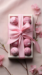 A box filled with heart-shaped pink chocolates, each tied with a ribbon, representing love and confectionery artistry.