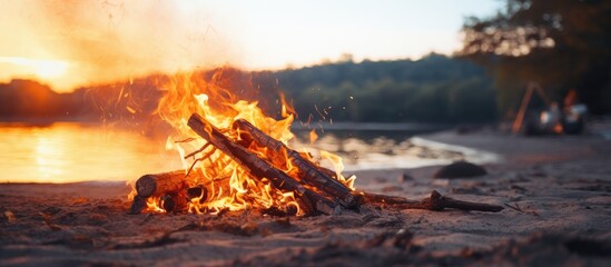 Fire no longer burning on the sand. Used fire on the shore. Fire no longer burning. Burnt wood fire by the river.
