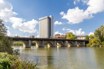 Valladolid, Spain - October 13, 2023: waters of the Pisuerga river with the bridge called Puente...
