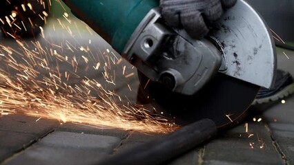 handyman cutting metal pipe by professional circular saw, closeup view, repair works
