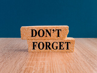 Do not forget symbol. Concept word Don't forget on brick blocks. Beautiful wooden table, dark blue...