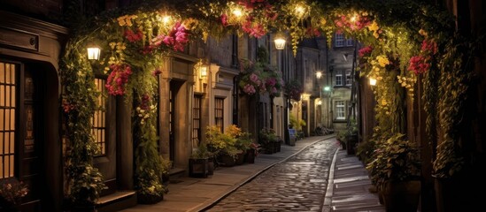 Archway with lights over alleyway on the Royal Mile in Edinburgh, Scotland, adorned with flowers and greenery.