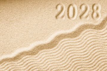 Fototapeta na wymiar Imprints of numbers 2028 new year on a golden sand waves