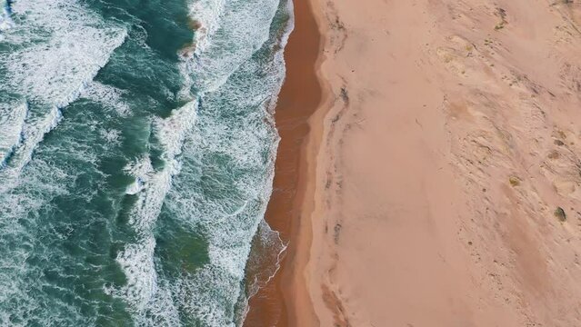 Sandy beach at Big Sur along Highway One in California. Famous road trip route. Slow motion aerial.
