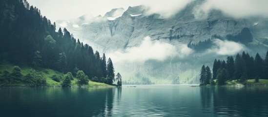 Hazy fog over clear Oeschinensee Lake. Misty Swiss Alps backdrop.