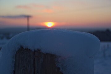 Stimmungsvoller Sonnenuntergang am kalten Winterabend nach dem ersten Schnee