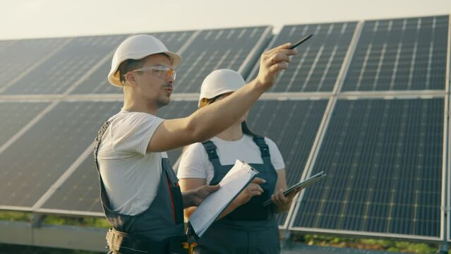 An engineer and his assistant check the operation of solar panels
