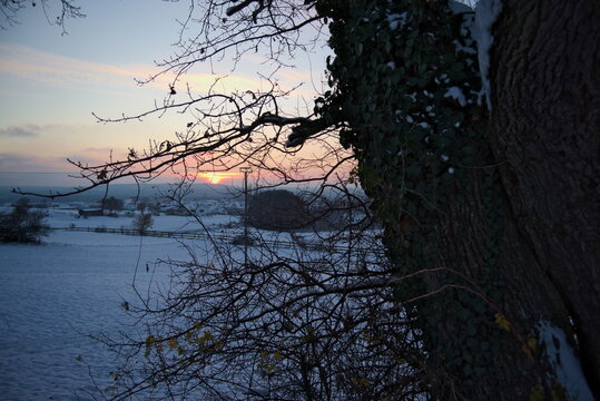 Stimmungsvoller Sonnenuntergang am kalten Winterabend nach dem ersten Schnee