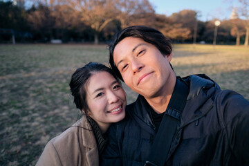 公園で自撮りをするカップル