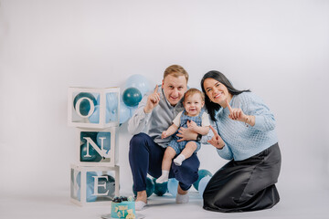 Naklejka premium Mother, father and son in the studio on the 1st anniversary with balloons