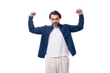 portrait of a young handsome brutal brunette guy in a denim shirt on the background with copy space