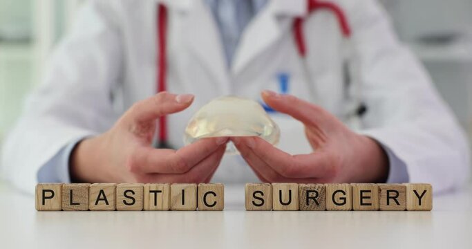 Woman expert holds implant near phrase Plastic Surgery on cubes
