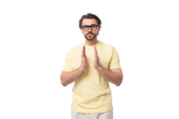 Fototapeta premium young smart brunette man in a t-shirt and glasses on a white background with copy space