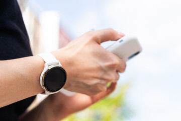 phone in the hands of a girl and a smart watch on her hand mockup