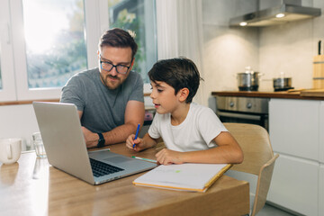 Father is helping his son trudy for the test.