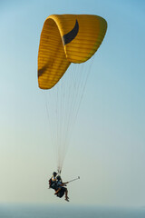 Paragliding in the sky over the sea. The concept of parachute flight. Tandem skydiver pilot and...