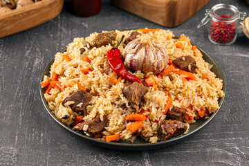 Large dish with Uzbek festive pilaf plov on grey background