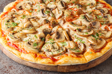 Pizza ai funghi or Pizza with Mushrooms with tomato sauce, mozzarella, herbs and garlic close-up on a wooden board on the table. Horizontal