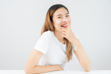 Fototapeta premium Beautiful Asian woman smile use cream touch on nose skin. face of a healthy woman apply cream and makeup. Advertisement for skin cream, anti-wrinkle, baby face, whitening, moisturizer, tighten pores