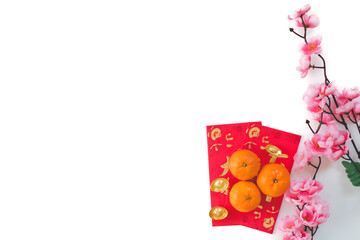 Top view of the Mandarin orange on red envelopes and gold ingot decorated with plum blossom...