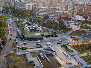 Elevated drone view of bustling traffic and urban landscape at sunset, facing east from Piazza...