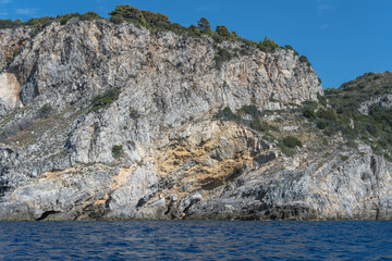 steep colorful cliffs on Cala Grande cape western side, Argentario, Italy