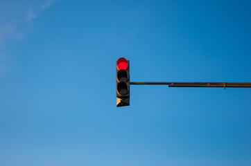 Traffic light showing red with blue sky background