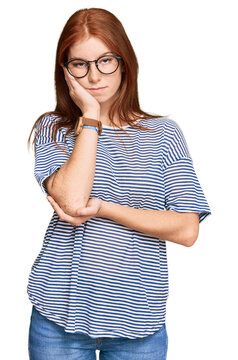Young read head woman wearing casual clothes and glasses thinking looking tired and bored with depression problems with crossed arms.