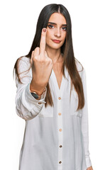 Young beautiful woman wearing casual white shirt showing middle finger, impolite and rude fuck off expression