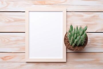 top view photo frame mock up and cactus. Cactus in pot and blank photo frame on wooden table.