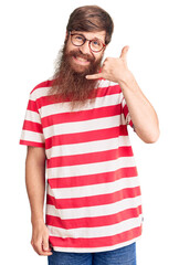 Handsome young red head man with long beard wearing casual clothes smiling doing phone gesture with hand and fingers like talking on the telephone. communicating concepts.