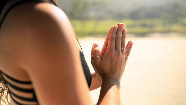 Hands, beach and closeup of woman praying for a meditation exercise for zen, health and wellness. Calm, spiritual and zoom of female person in yoga pose for mind, body and chakra balance by the ocean