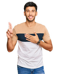 Young handsome man wearing casual clothes smiling swearing with hand on chest and fingers up,...