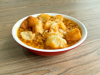 homemade boiled traditional Chinese hot tau suan sweet soup with deep fried crispy you tiao donut in bowl on wood table yummy asian halal dessert cafe food menu restaurant