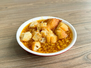 homemade boiled traditional Chinese hot tau suan sweet soup with deep fried crispy you tiao donut in bowl on wood table yummy asian halal dessert cafe food menu restaurant