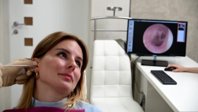 otolaryngologist conducts medical examination of ear with otoscope closeup
