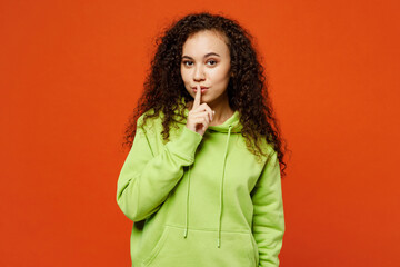 Young secret fun woman of African American ethnicity she wear green hoody casual clothes say hush...