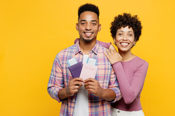 Traveler fun couple two friends family man woman wear casual clothes hold passport ticket isolated on plain yellow background. Tourist travel abroad in free time rest getaway. Air flight trip concept.