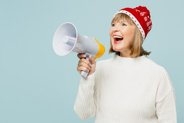 Merry surprised excited elderly woman 50s year old in sweater red hat posing scream in megaphone...